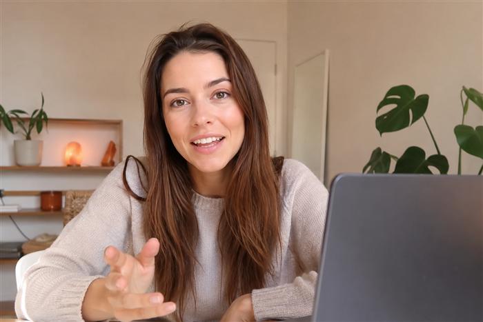 Illustrative UGC-style info product ad frame: talking to camera at a desk with a laptop